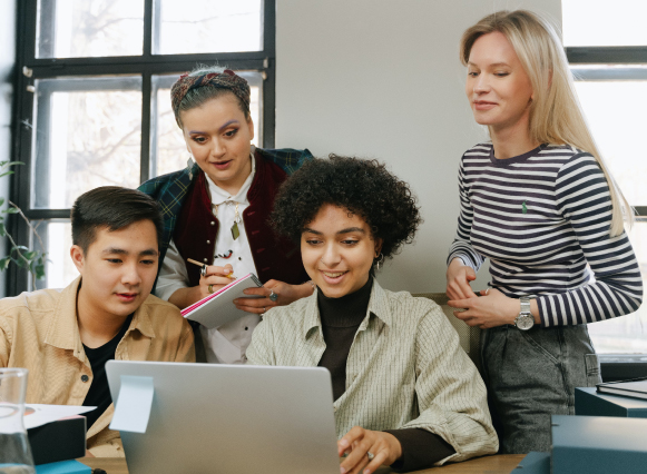 A team sitting around a computer analyzing their marketing.