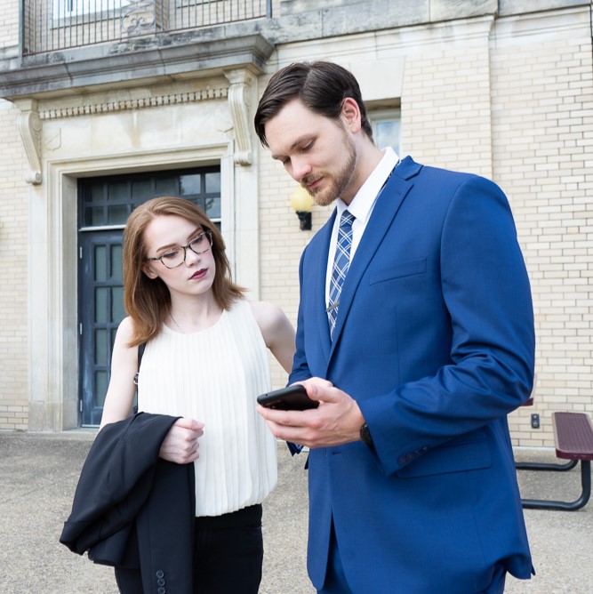 Two People Looking At A Cell Phone