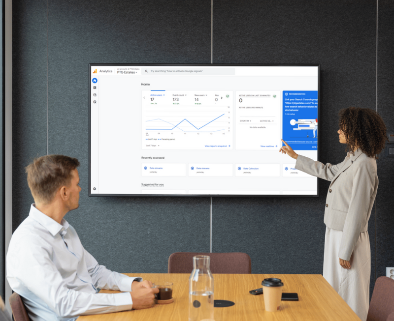 Two people reviewing Analytics on a television screen
